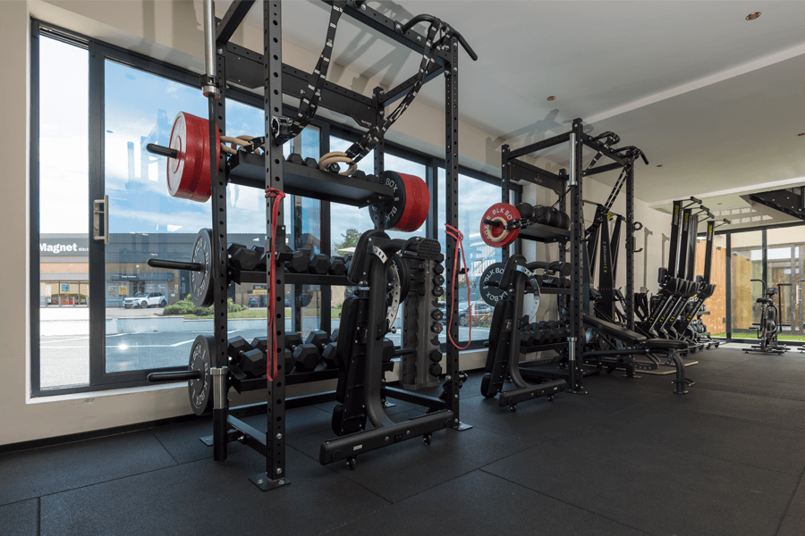 Gym weight racks in front of open sliding doors