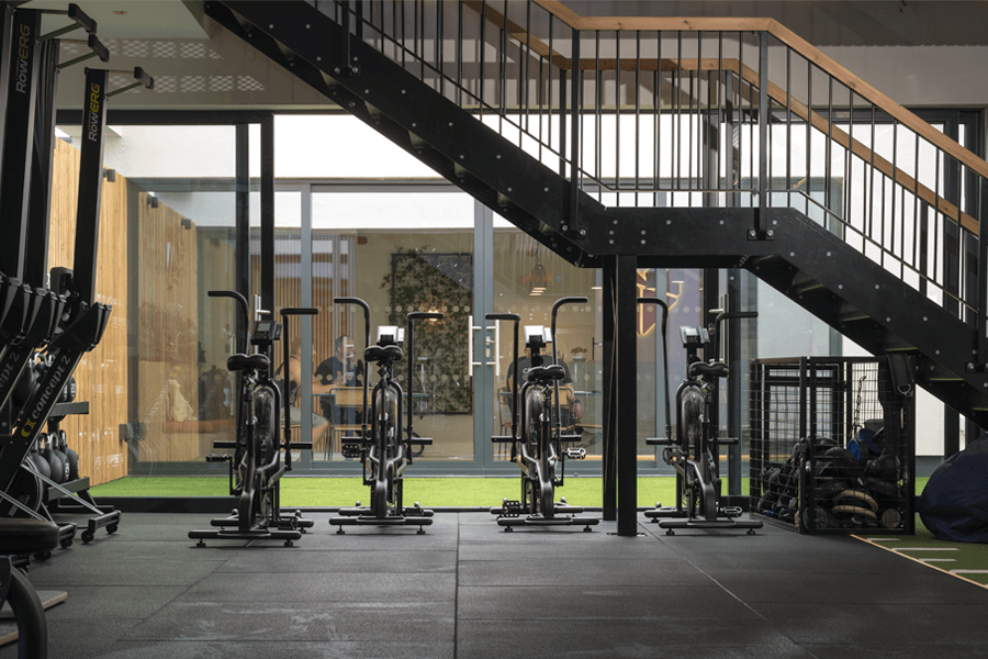 Gym exercise bikes in front of open sliding doors